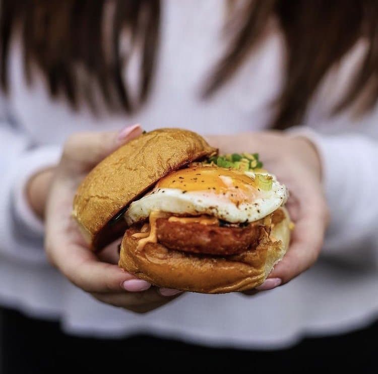 Women holding a sandwich with an egg
